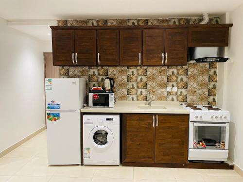 a kitchen with a white refrigerator and a dishwasher at Terrace View Serviced Apartments 2 in Al Khobar