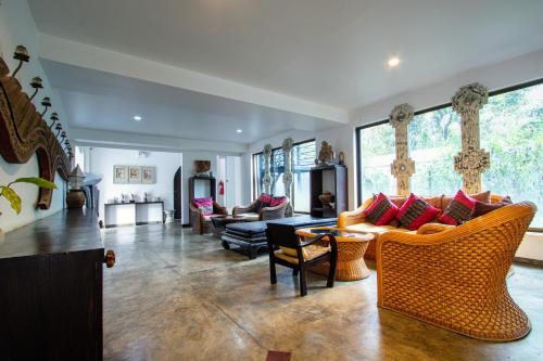 a living room with couches and chairs at Gudi Boutique Hotel in Mae Rim
