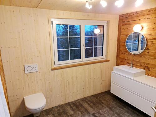 a bathroom with a toilet and a sink and a window at Grosses Ferienhaus für traumhafte Familienferien im Appenzellerland in Speicher