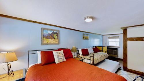 a bedroom with a large orange bed and a couch at Pack Creek ~ Creekside East in Moab
