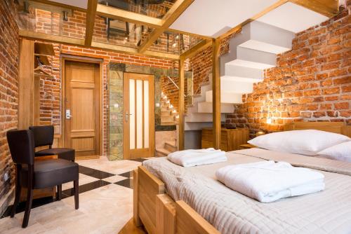 a bedroom with two beds and a brick wall at Aparthotel Stare Miasto in Krakow