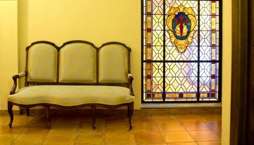 a chair in a room with a stained glass window at Hotel Don Carlos Cáceres in Cáceres