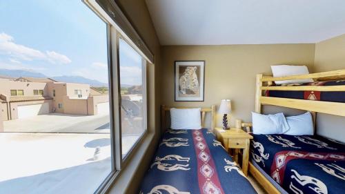 a bedroom with two bunk beds and a large window at Saddle Creek #3A1 in Moab