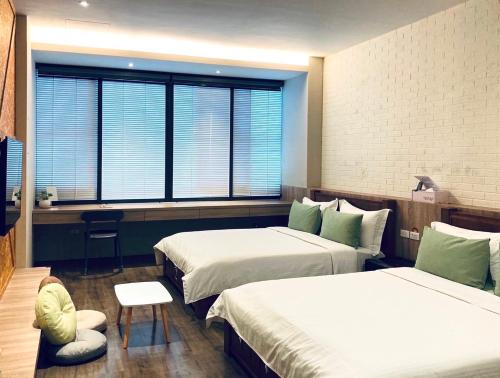 a hotel room with two beds and a window at Enjoy Homestay in Tainan