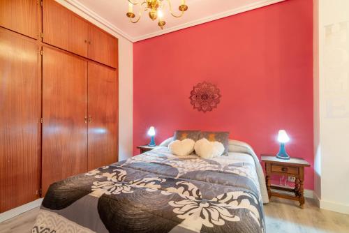 1 dormitorio con paredes rojas y 1 cama con 2 ositos de peluche en Casa El Trinquete, en Cenicero