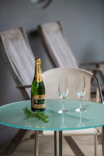 a bottle of champagne on a table with two wine glasses at Rhyll Haven Luxury Getaway Apartments in Rhyll