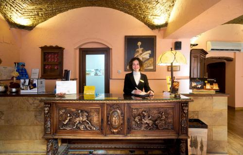 a woman standing in front of a counter in a kitchen at Hotel Don Carlos Cáceres in Cáceres