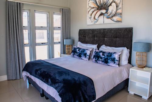 a bedroom with a large bed and a window at Exclusive Poolside Villa, Humewood in Port Elizabeth