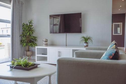 uma sala de estar com dois sofás e uma mesa em Exclusive Poolside Villa, Humewood em Port Elizabeth