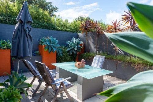 a patio with a table and chairs and an umbrella at Rhyll Haven Luxury Getaway Apartments in Rhyll