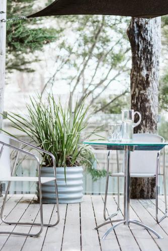 a glass table and two chairs on a porch at Rhyll Haven Luxury Getaway Apartments in Rhyll