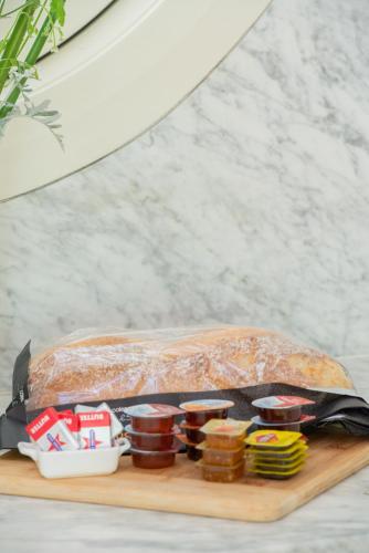 a loaf of bread sitting on a cutting board with jam at Rhyll Haven Luxury Getaway Apartments in Rhyll