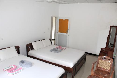 Zimmer mit 2 Betten und einem Kühlschrank in der Unterkunft The Sisara in Kataragama
