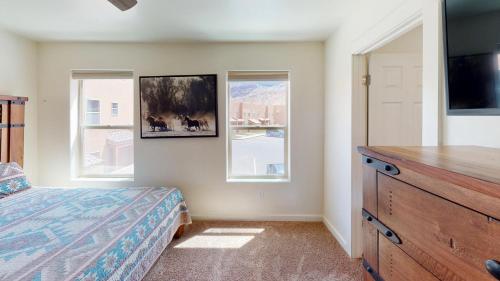 a bedroom with a bed and a dresser and two windows at Wildhorse Canyon #14A3 in Moab