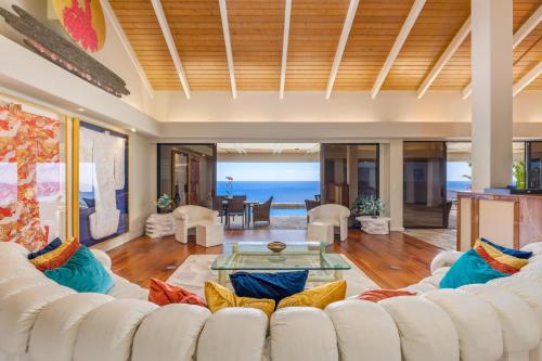 a living room with a white couch and a table at Waterfall House - Hawaii in Kailua-Kona