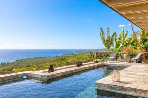 a swimming pool with a view of the ocean at Waterfall House - Hawaii in Kailua-Kona