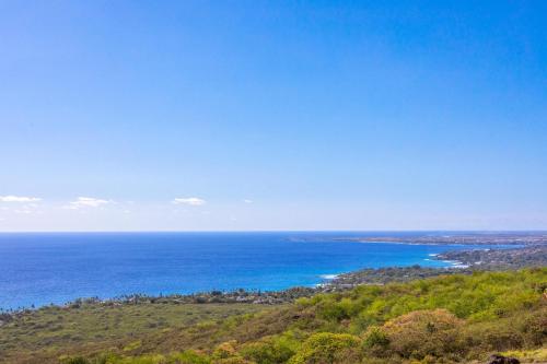 a view of the ocean from the top of a hill at Waterfall House - Hawaii in Kailua-Kona