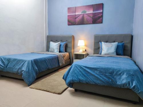 two beds sitting next to each other in a bedroom at The Hidden Gems in Pantai Cenang