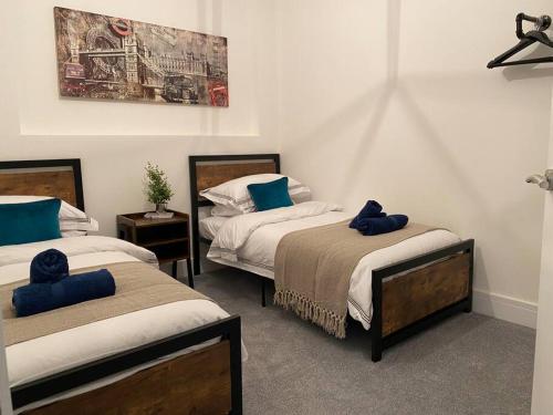 Flat 2, 3 bed New York inspired apartment-Swan F2 في سوانسي: غرفة نوم بسريرين عليها وسائد زرقاء