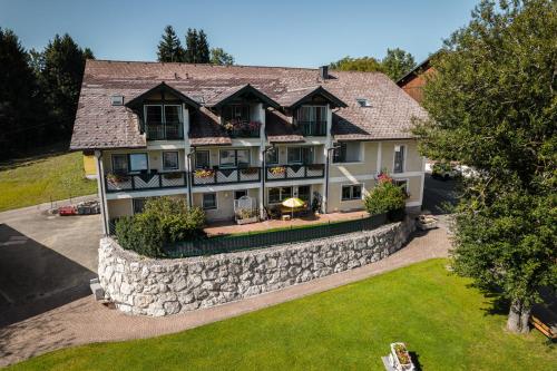 an aerial view of a large house with a stone wall at Voralpenhotel Schmoller in Sankt Georgen im Attergau