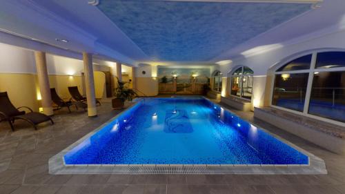 a large swimming pool in a hotel room at Voralpenhotel Schmoller in Sankt Georgen im Attergau