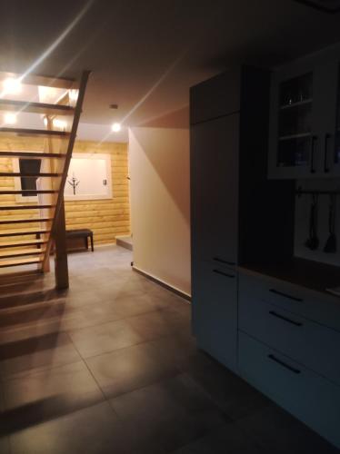 a living room with a staircase and a dresser at Gościnna Chata Domek in Jaworki