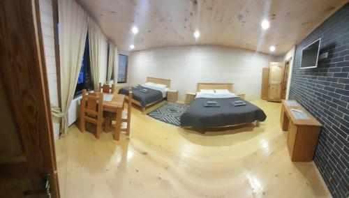 a room with two beds and a table and chairs at Berloga Pylypets in Pilipets