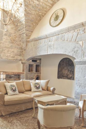 un salon avec un canapé et un mur en pierre dans l'établissement Château De Chaussy, à Ruoms
