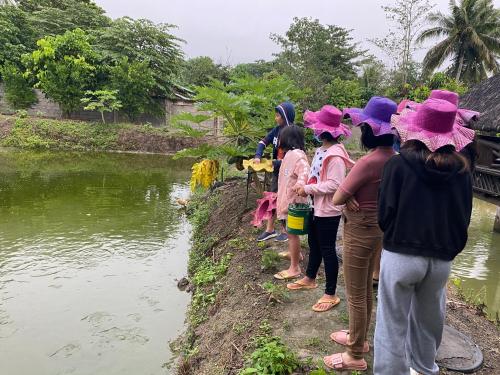 a group of people in hats looking at a river at The Family Farm Stay in Cauayan City