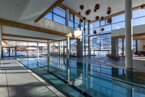 a pool in a building with glass windows at Woferlgut - Wellness & Sport in Bruck an der Großglocknerstraße