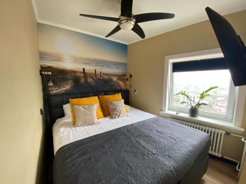 a bedroom with a bed with a ceiling fan at Apartment Malisa in Zandvoort