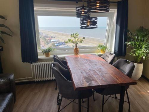 a dining room with a table and a large window at Apartment Malisa in Zandvoort