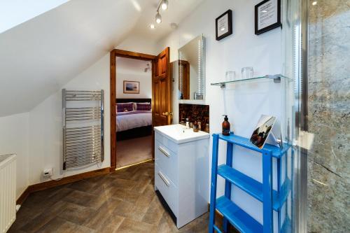 a bathroom with a sink and a room with a bed at Ceol na Mara Guest House in Tarbert
