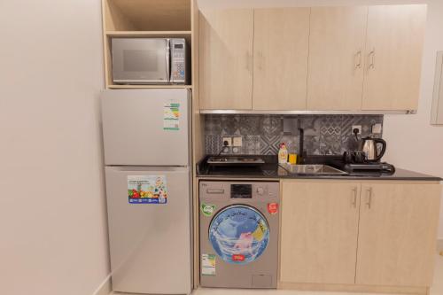 a kitchen with a refrigerator and a washing machine at أحلى الأيام للوحدات الفندقية-محايل عسير in Muhayil