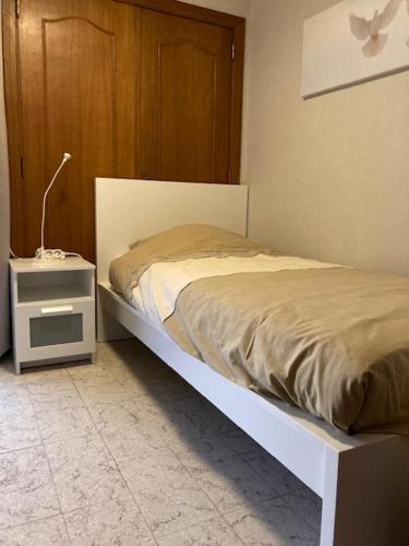 a bedroom with a bed and a night stand with a lamp at Vakantiehuis in Vlaamse Ardennen in Zottegem