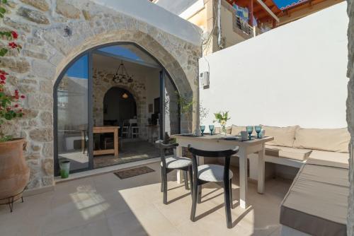 a living room with an archway and a table and chairs at Stonehouse South Crete in Vóroi