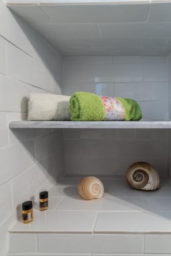 a shelf with towels and other items on it at Stonehouse South Crete in Vóroi