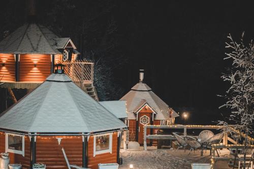 a house with snow on the roofs at night at The Mangevie in Furudal