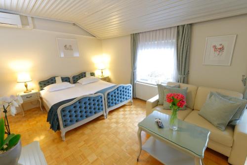 a hotel room with a bed and a couch at ApartHotel Vila Minka in Ljubljana