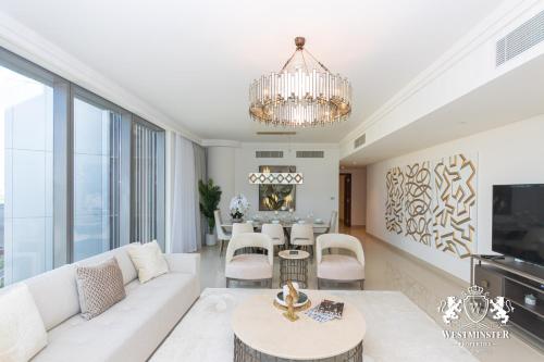 sala de estar con sofá blanco y lámpara de araña en Westminster Boulevard Point, en Dubái