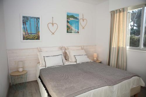 een slaapkamer met een bed en twee harten aan de muur bij T3 tout confort PLAGE A 20 METRES in Saint-Cyr-sur-Mer