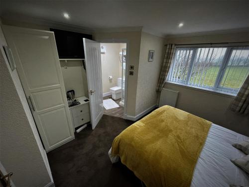 a bedroom with a bed with a yellow blanket on it at Southpark House in Dumfries