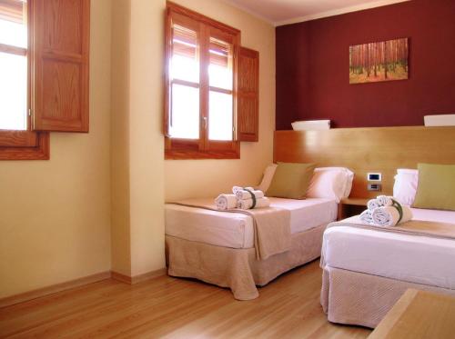 a room with two beds and a window at Hotel La Tinensa in Puebla de Benifasar