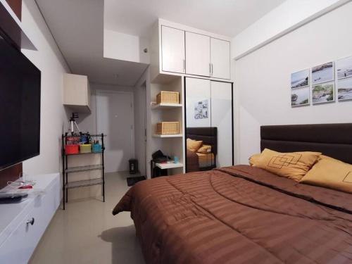 a bedroom with a large bed and a television at A Peaceful Room at Barsacity Apartment by Ciputra in Seturan