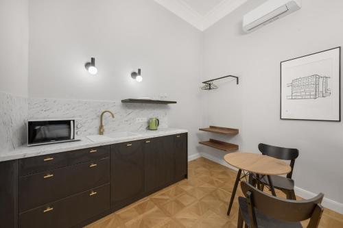 a kitchen with a sink and a table at Palace Apartments in Bratislava