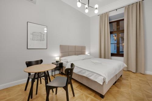 a bedroom with a bed and a table and chairs at Palace Apartments in Bratislava