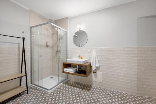 a white bathroom with a sink and a shower at Palace Apartments in Bratislava