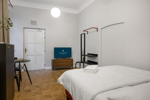 a bedroom with a bed and a table and a tv at Palace Apartments in Bratislava