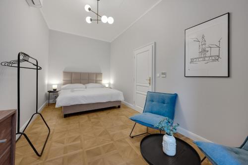 a bedroom with a bed and a blue chair at Palace Apartments in Bratislava