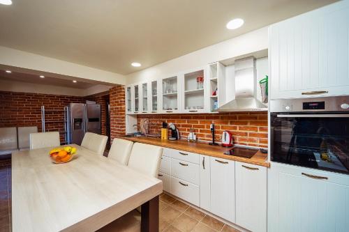 a kitchen with white cabinets and a table with fruit on it at Villa Makeli in Rogachevo